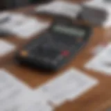A calculator and tax forms laid out on a wooden table.